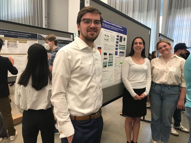 Annelie Minor, Emma Volkmann, and William Hancock standing in front of their poster